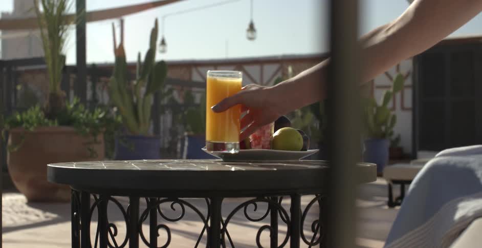 A person walks over and grabs a glass of juice