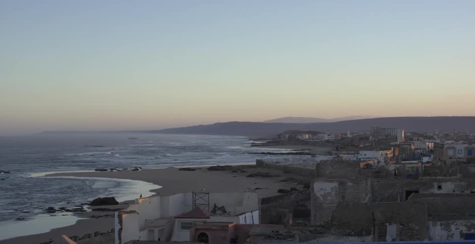 An ocean side city at sunrise