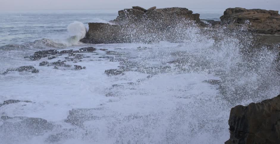 Water splashing up on rocks on a beach