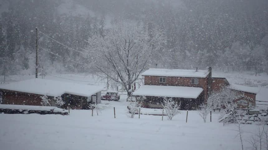 The snow slowly falls over the home ahead