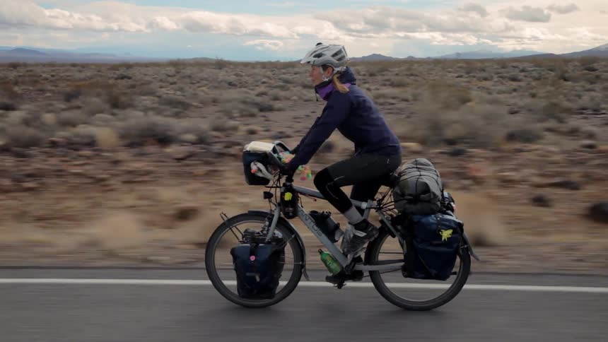 A person rides an electric bike through the desert