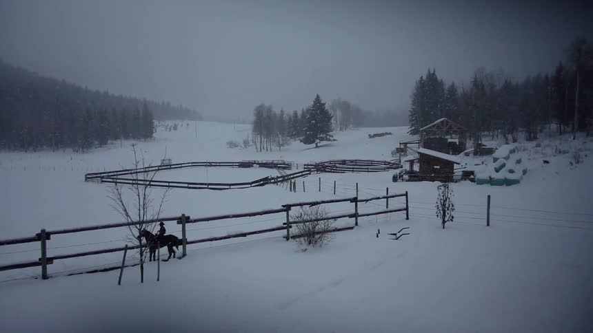 A ranch is shown on a snowy day