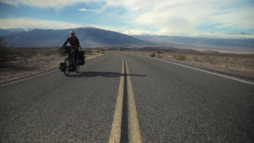 A cyclist rides with saddle bags on her bike