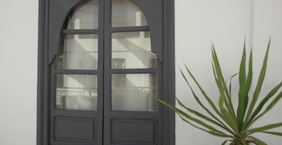 Woman walking down a street as seen in a reflection from a door window