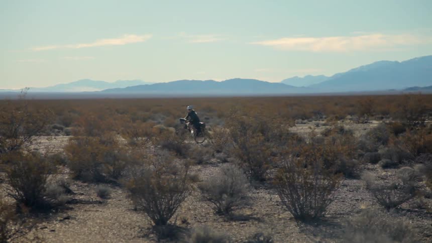 A person is riding their bicycle in the desert