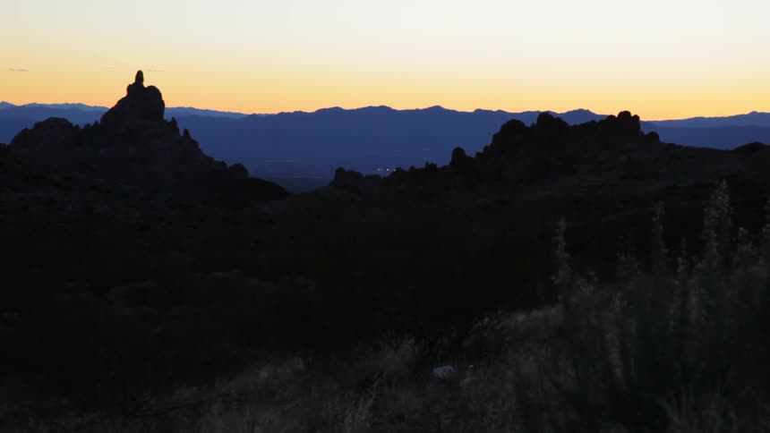 The mountains ahead have a sun setting behind