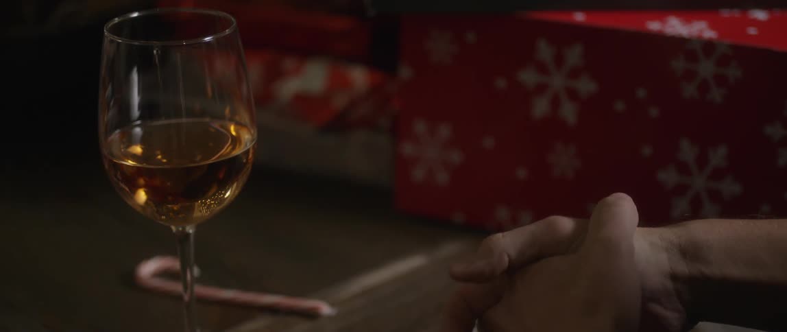 A person grabbing a glass of wine