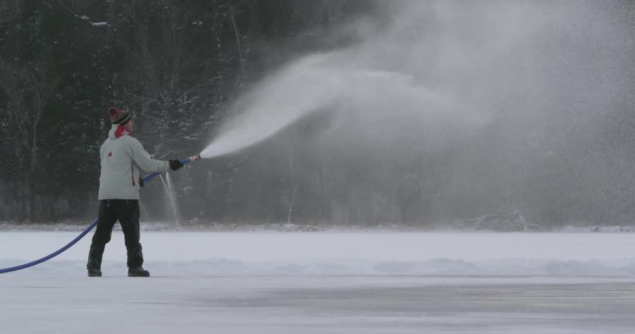 Person spraying water over a snow covered field