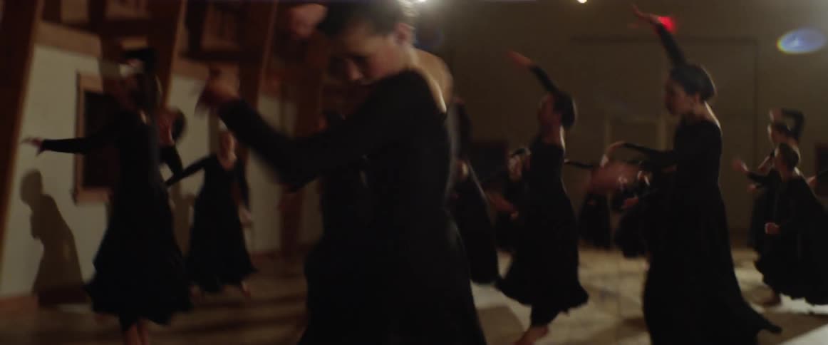 Women in black dresses dance very fast spinning all over in a group