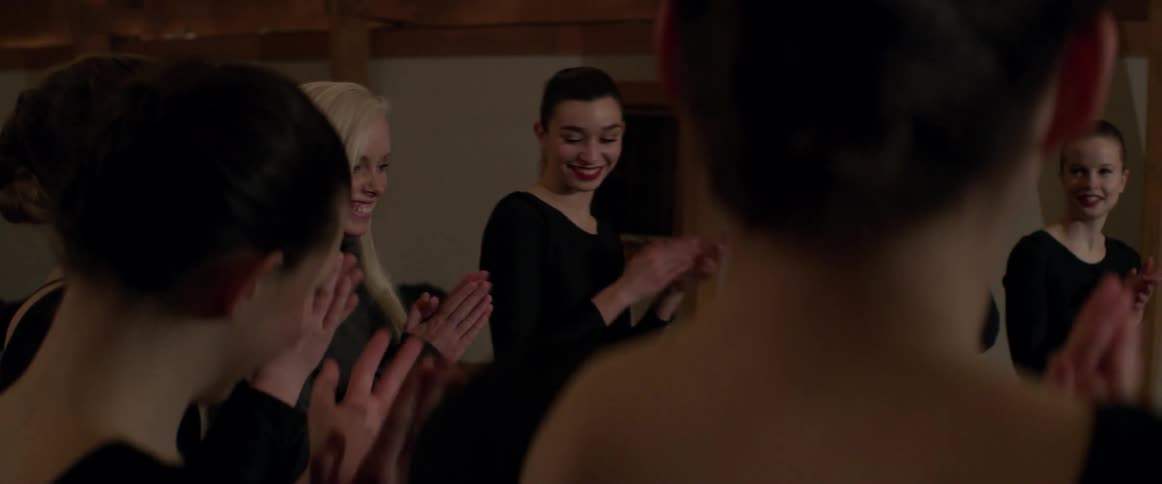 Women smile and clap together
