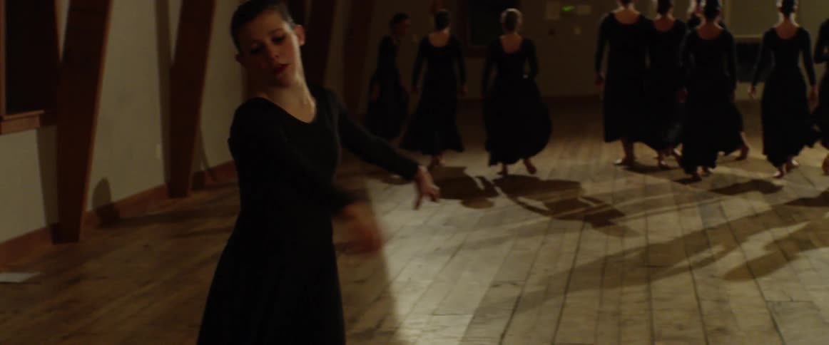 Dancers in black dresses perform a number