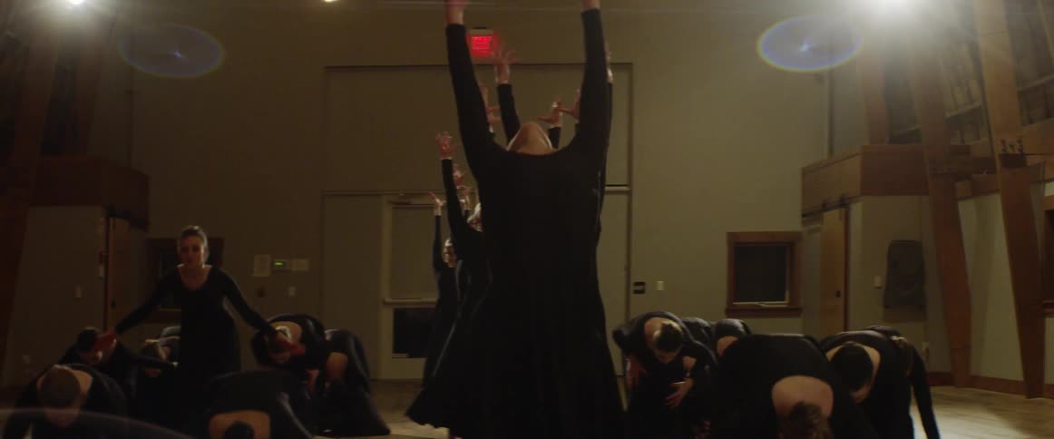 Women dance on the ground leaning backwards and forward