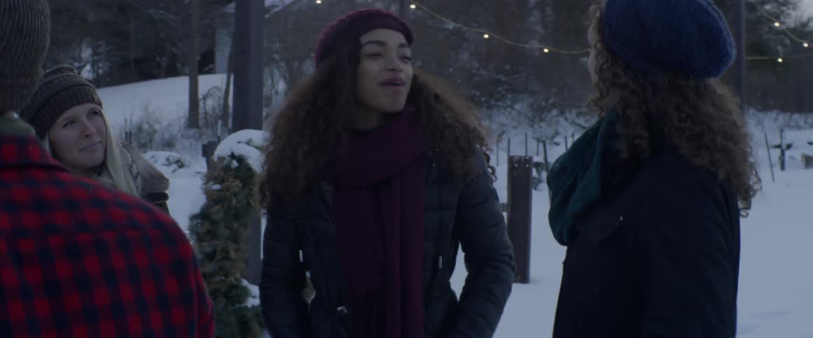 People stand outside in the snow talking