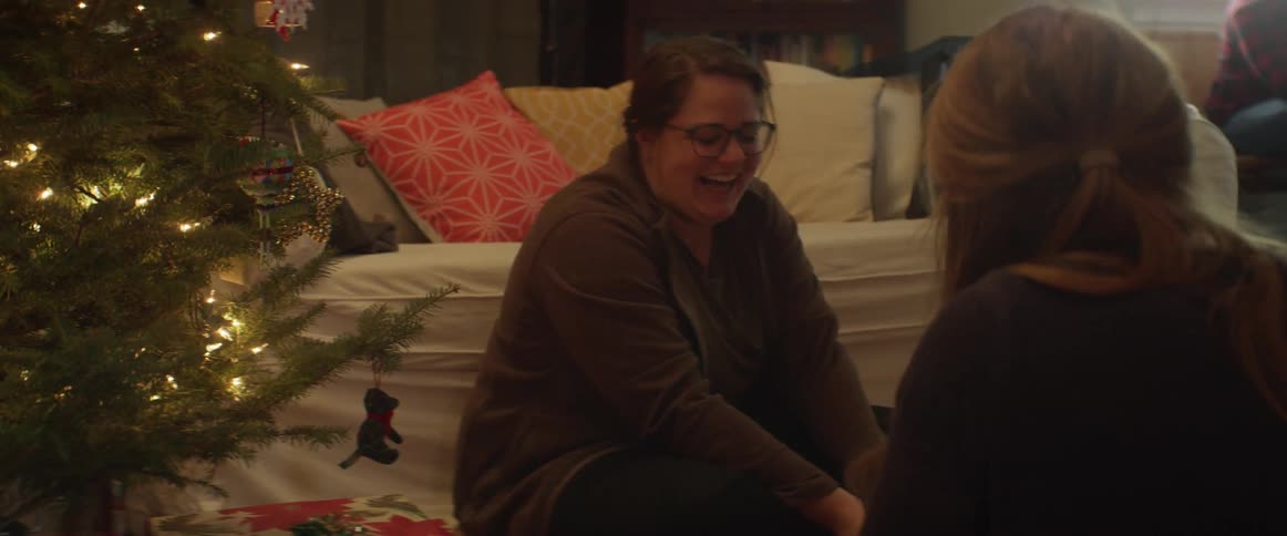 Women wrap christmas gifts on a living room floor