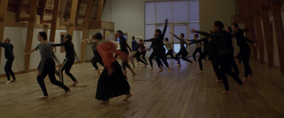 A woman runs in to join the other women dancing
