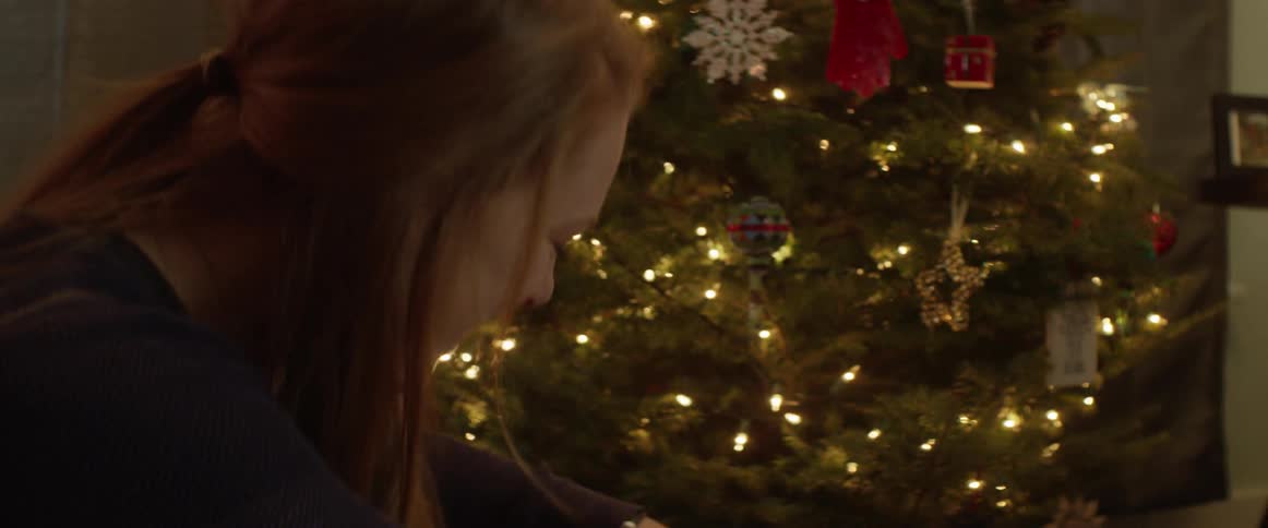 A woman is laughing and wrapping christmas presents