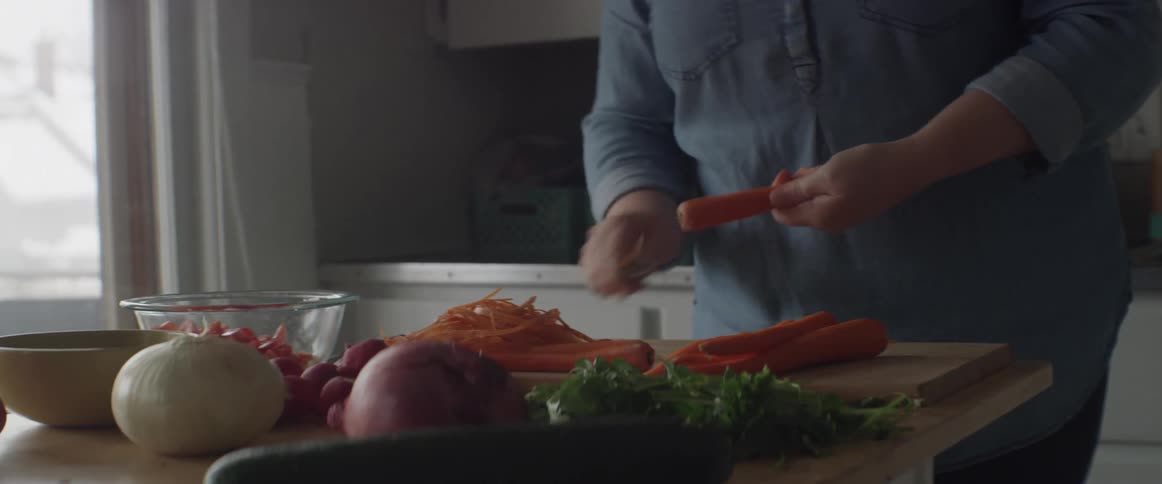 Person slices vegetables on a cutting board