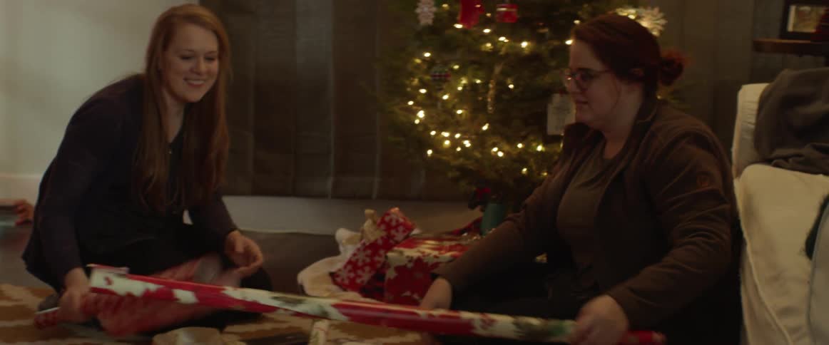 Women smile and talk as they wrap gifts