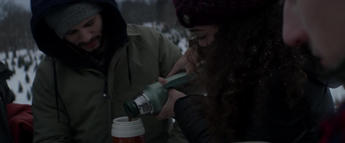 A group of people sharing a thermos full of cocoa