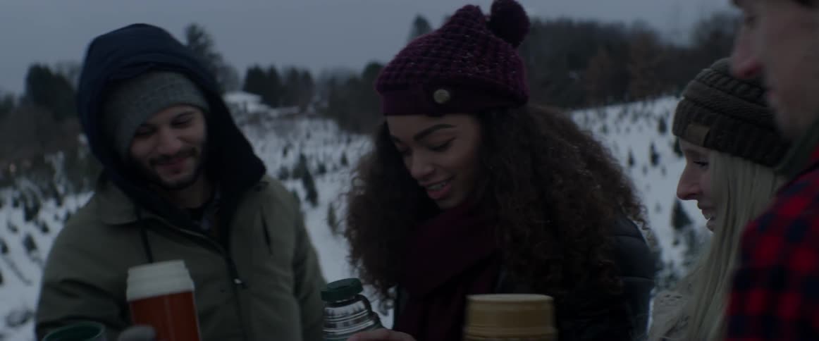A group of people toast with thermoses of hot chocolate outside on a snowy day