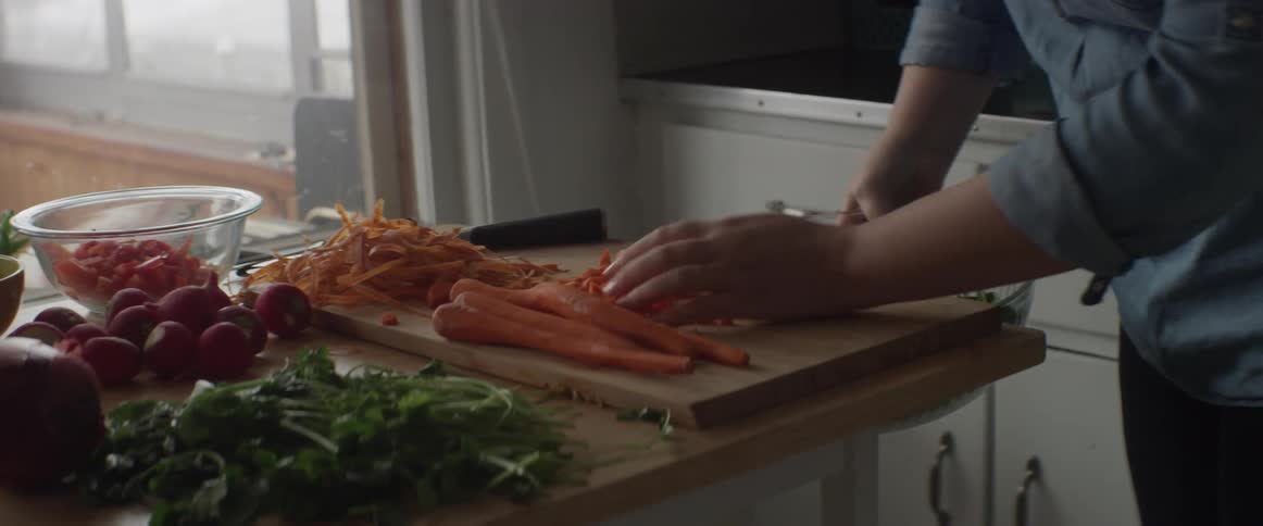 A chef scrapes vegetables into a bowl