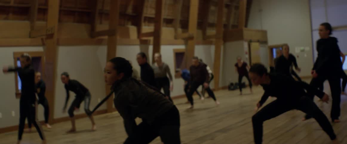 Dancers are performing together in all black