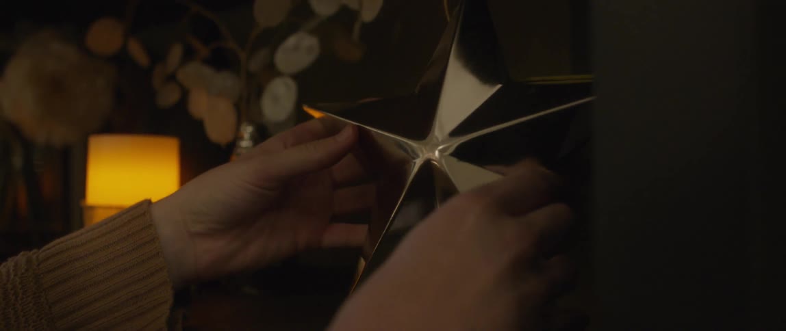 Hands putting a gold star on top of a mantel