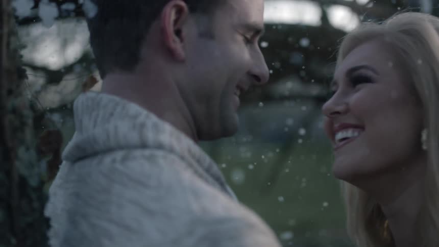A man and woman are hugging and smiling in the snow