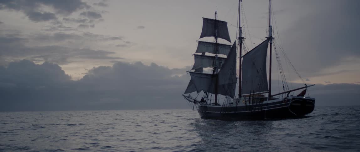 Ship sails in the ocean at sunset