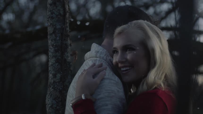Man and woman embrace as it snows