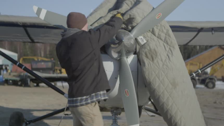 A person uncovering a plane
