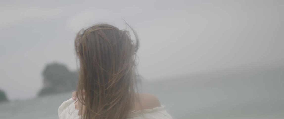 A woman turns around on the shore