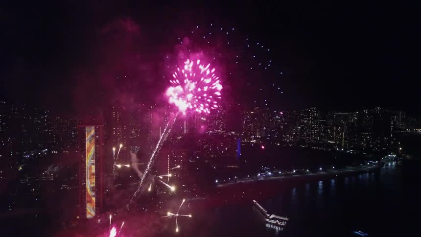 Fireworks explode over a city at night