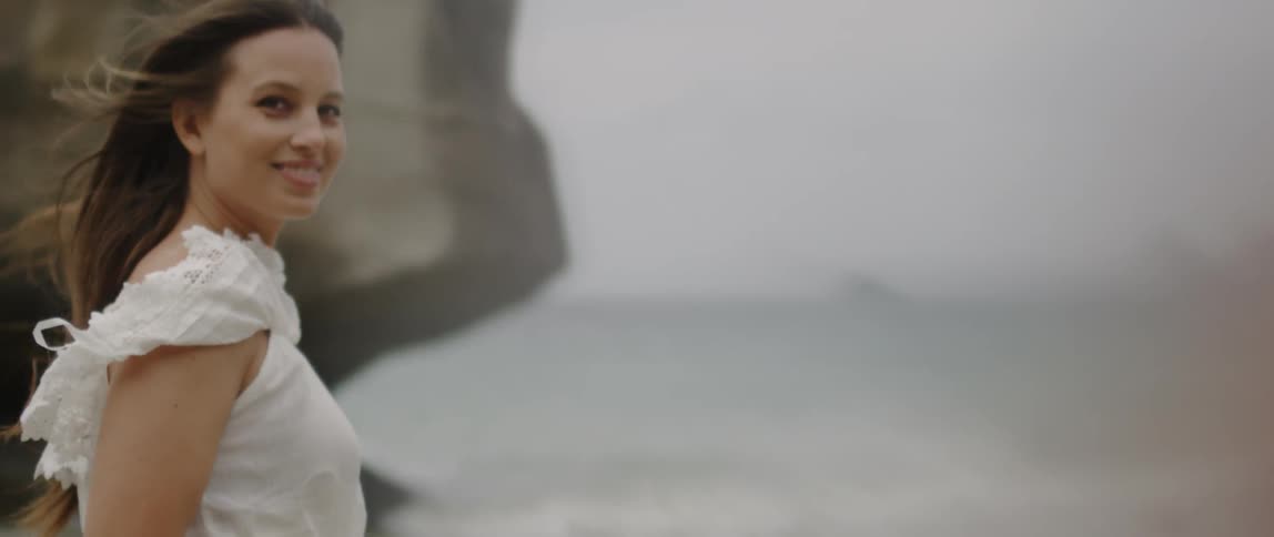 A woman walks on a beach on a windy day