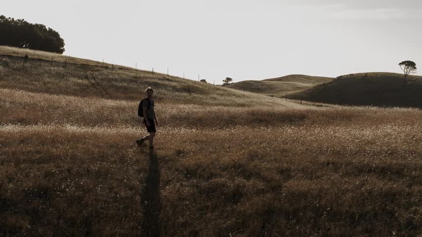 A man is hiking on a hill