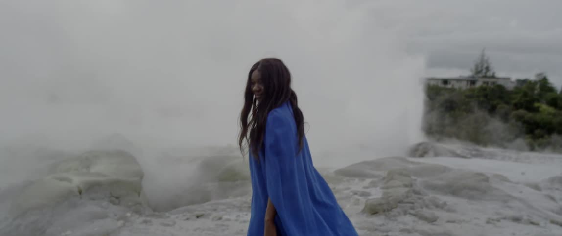 A woman walks slowly past the beach in blue