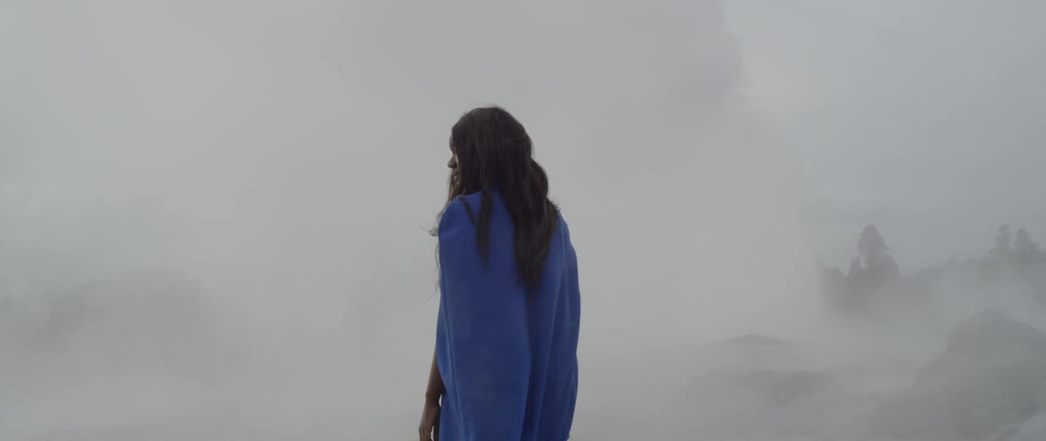 A woman standing in the midst of wind and fog