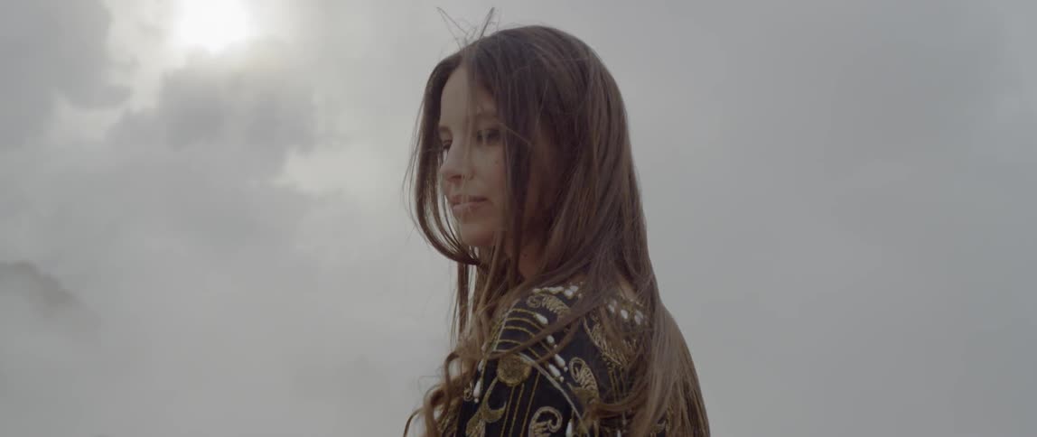 A woman is looking to her side on a cloudy day