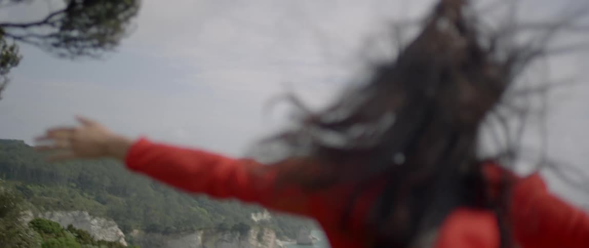 A woman spins in circles on a windy day