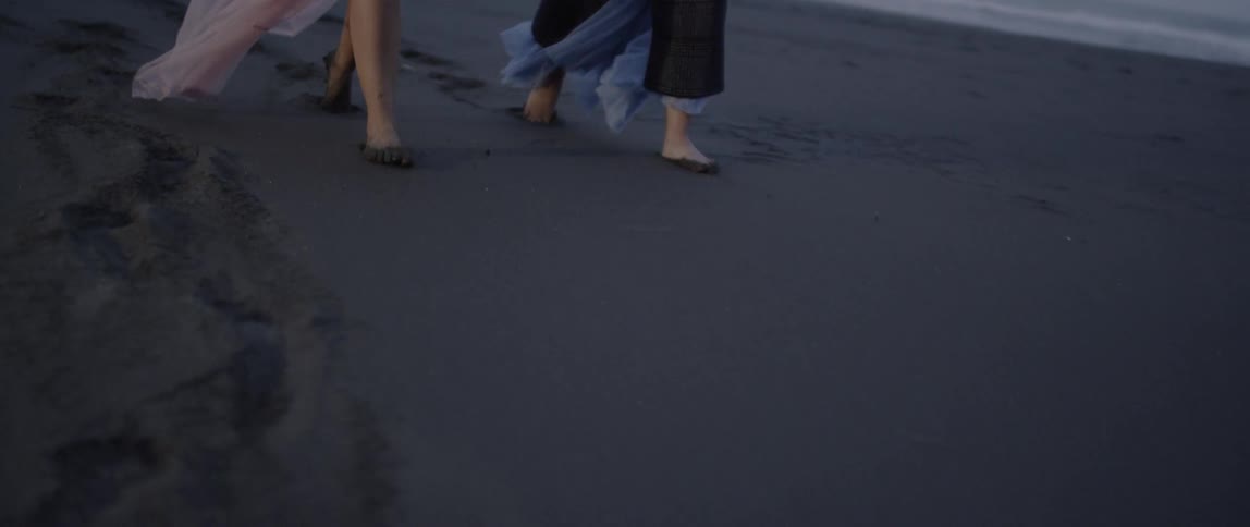 Two women walk on the beach