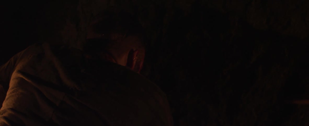 A man is searching around in the dark cave