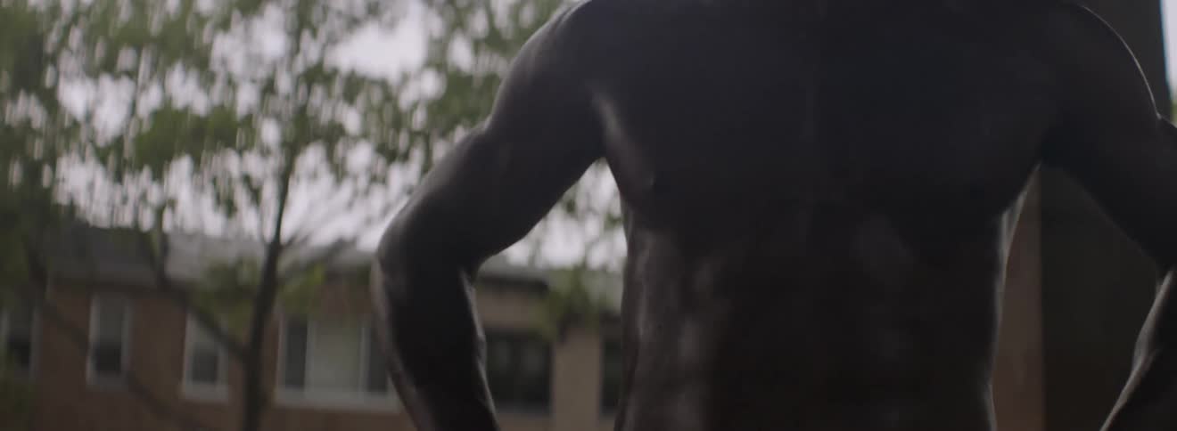 A man stretches outside shirtless