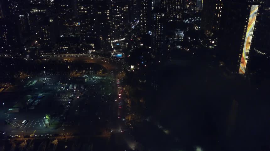 The city below is full of tall buildings and people driving around
