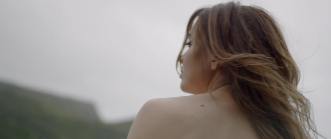A woman in a white dress is viewed from behind