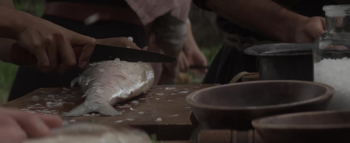 A person is cutting fish on a table