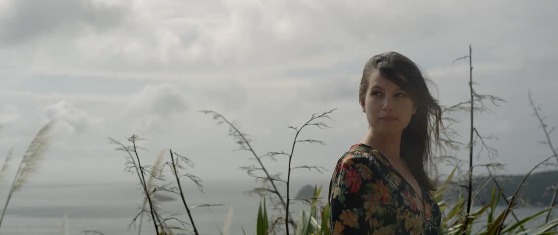The wind blows through a woman's hair on the coast
