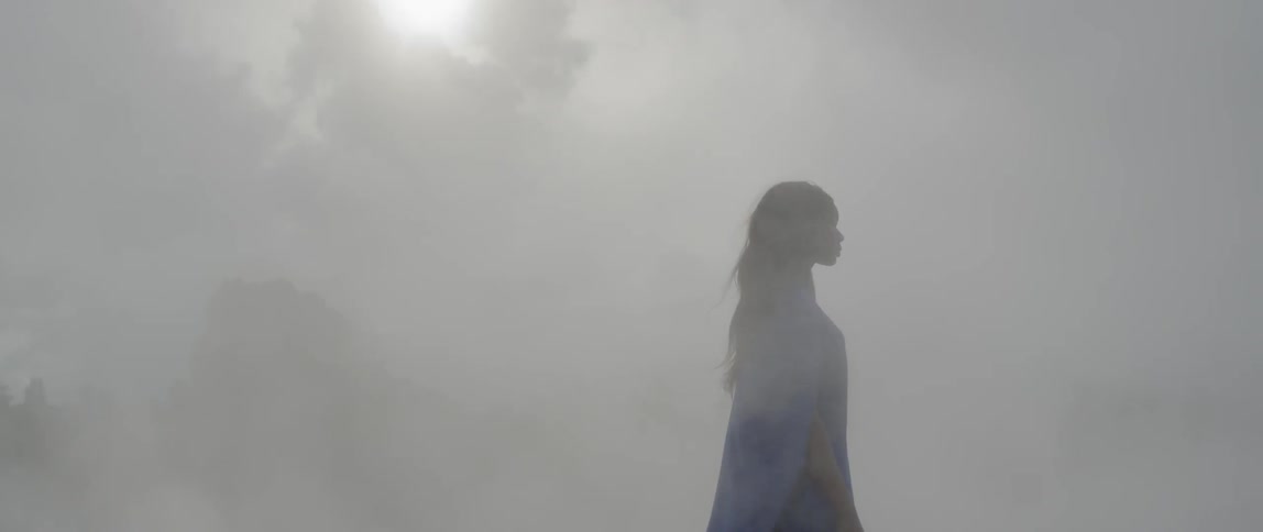Mist floats around a woman