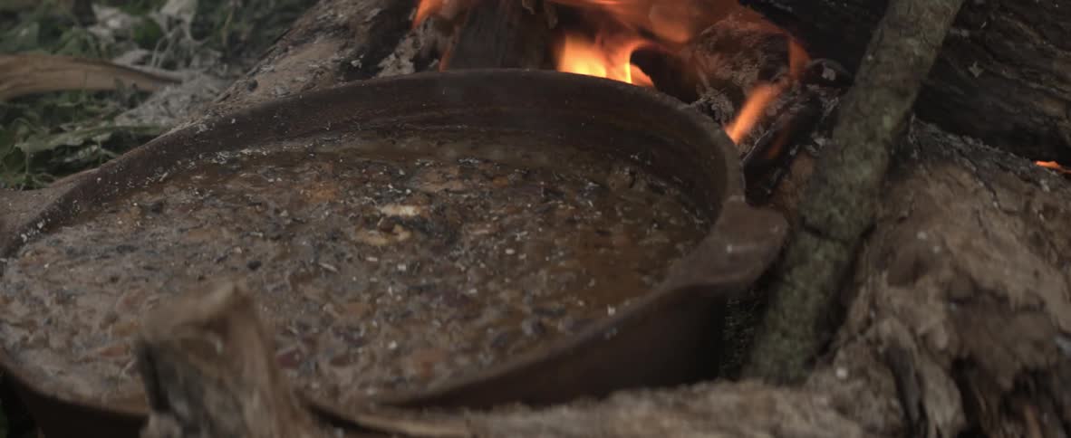 Kettle of beans bubbling over an open fire