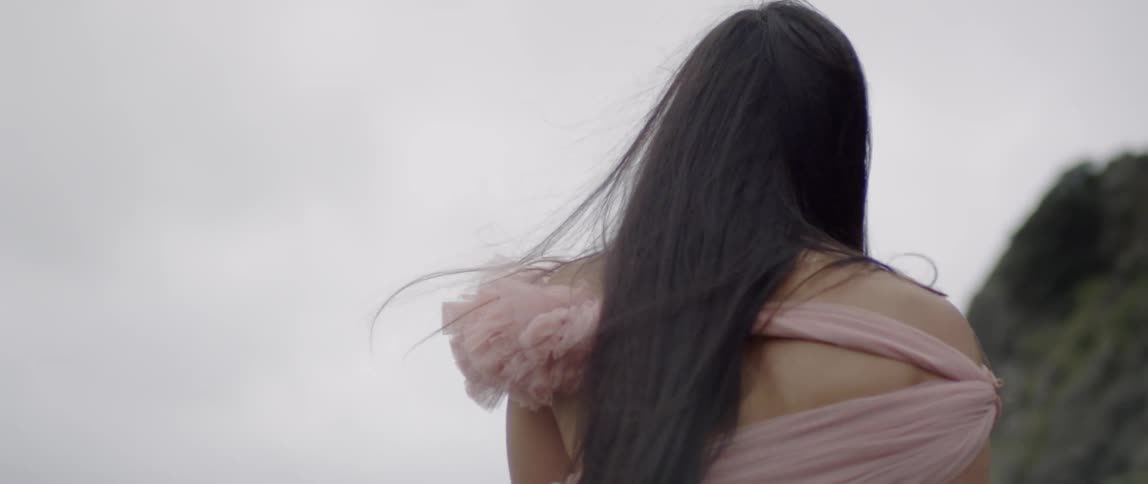 Woman with long hair walks near the mountains