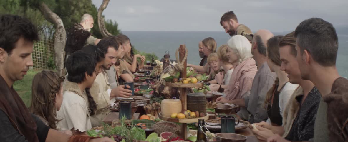 A large group of people are having an outdoor feast